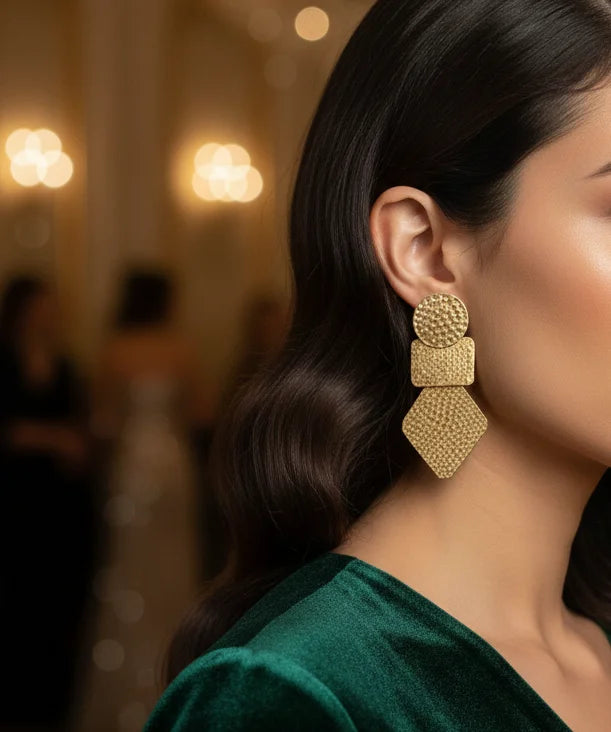 Gold textured geometric drop earrings on model, layered discs and teardrop shapes