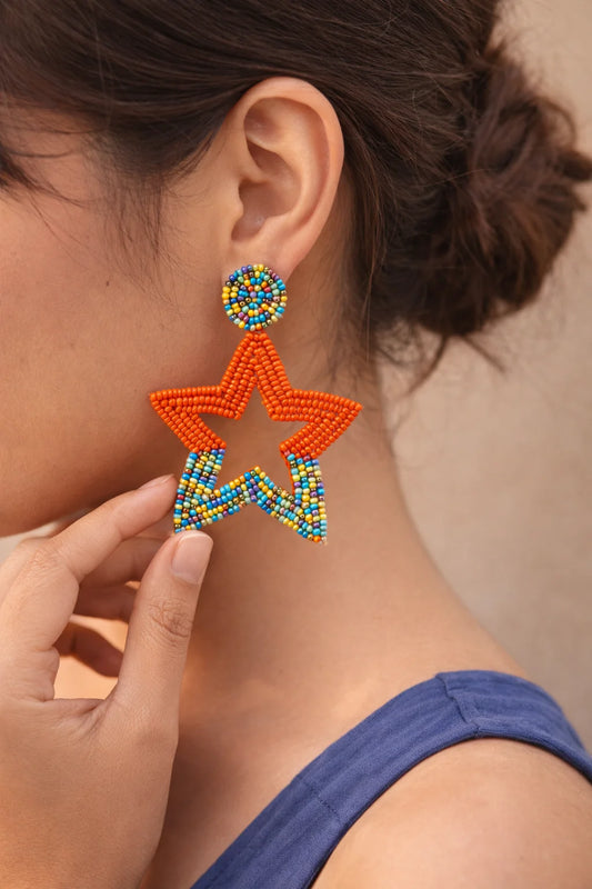Beaded starfish drop earrings on ear, orange starfish with turquoise bead bands