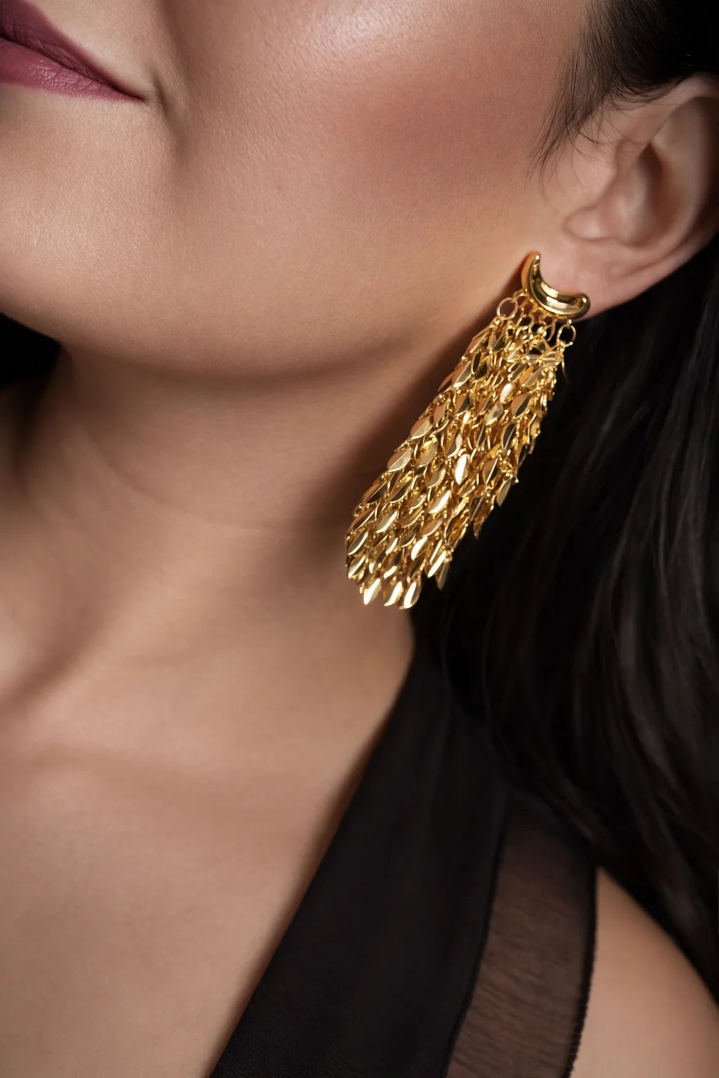 Gold-tone long drop earrings with chain fringe, worn on ear