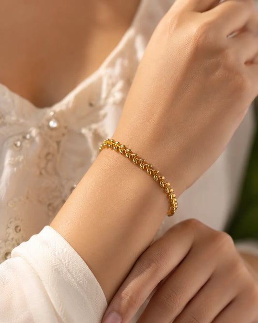 Gold-tone oval link bracelet worn on wrist with interlocking chain links