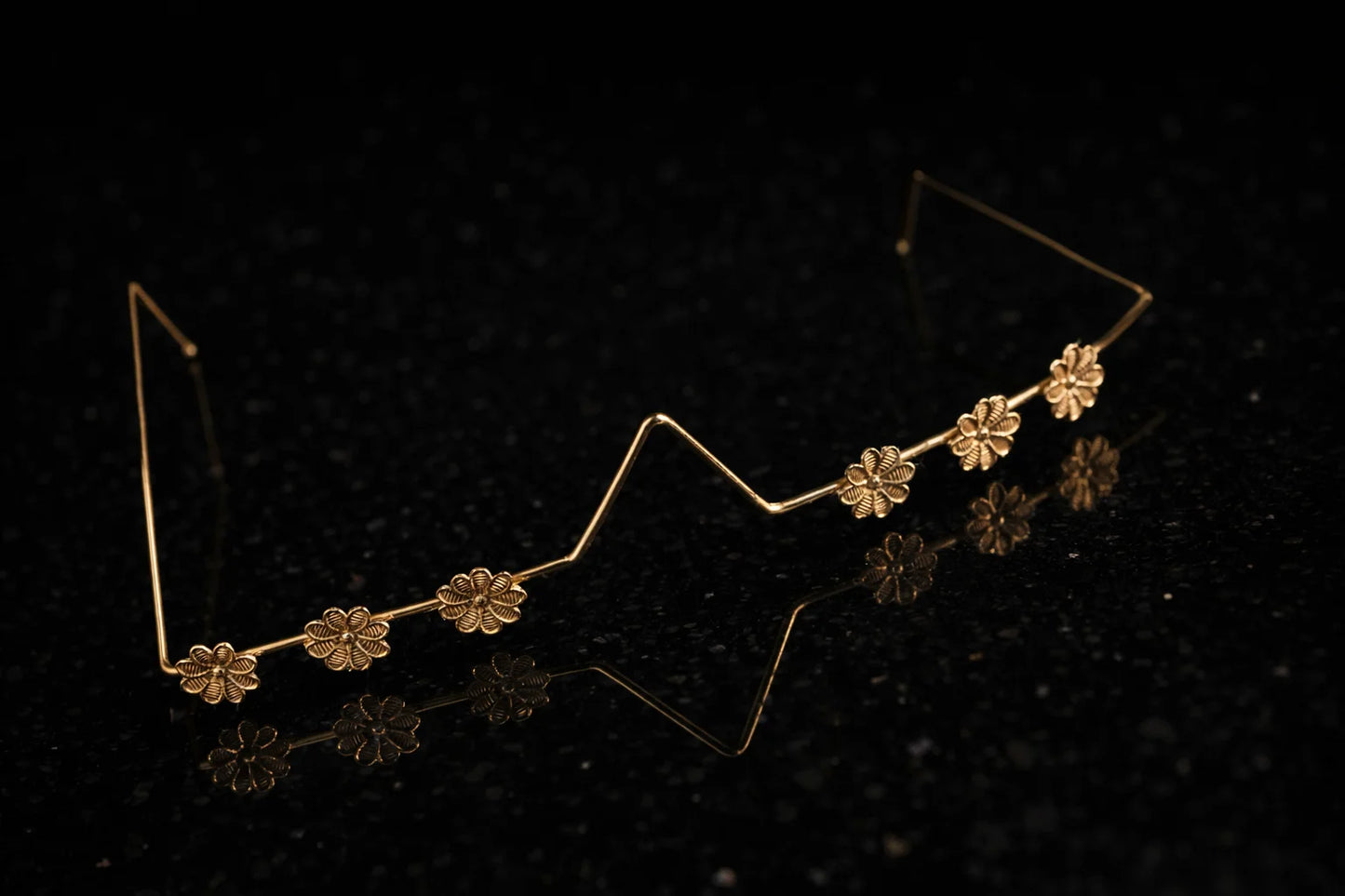 Gold-tone floral facelet band with zigzag wire and four-petal flower details