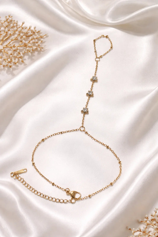 Gold-tone hand chain bracelet with dangling drop charms and small link segments