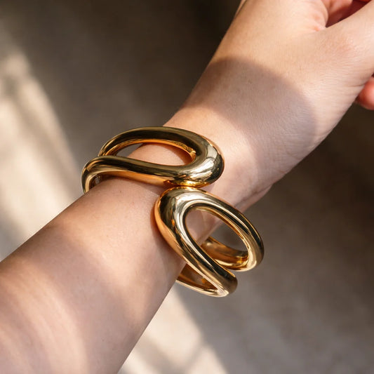 Gold chunky kada bangles stacked on wrist, glossy open oval links