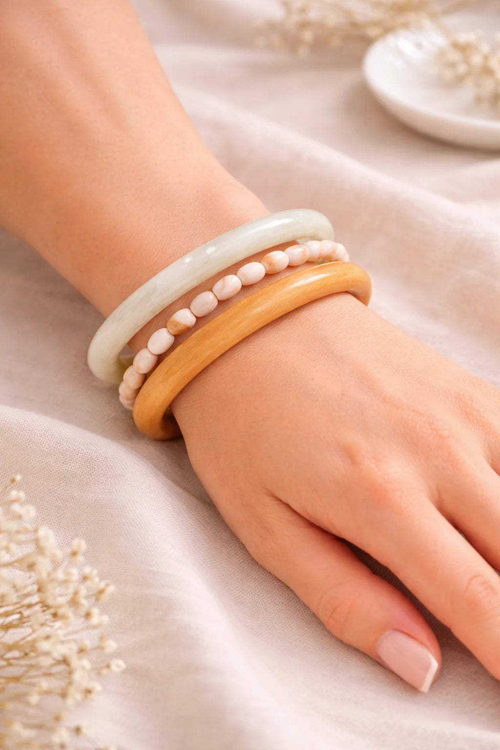 White resin and wooden kada bangles with pearl-like bead accent on wrist