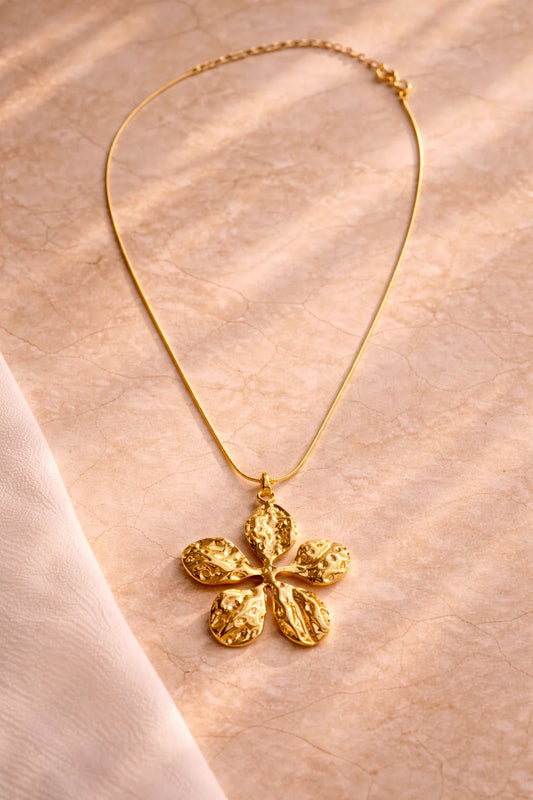 Gold-tone flower pendant necklace with textured five-petal charm and linked chain, full length