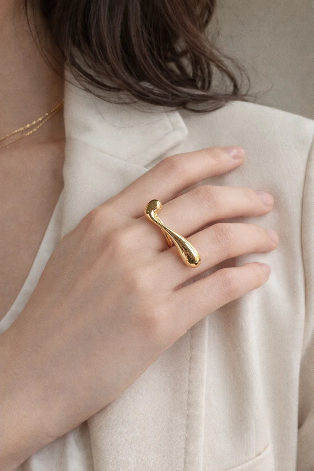 Gold-tone sculptural ring with rounded ends on curved band