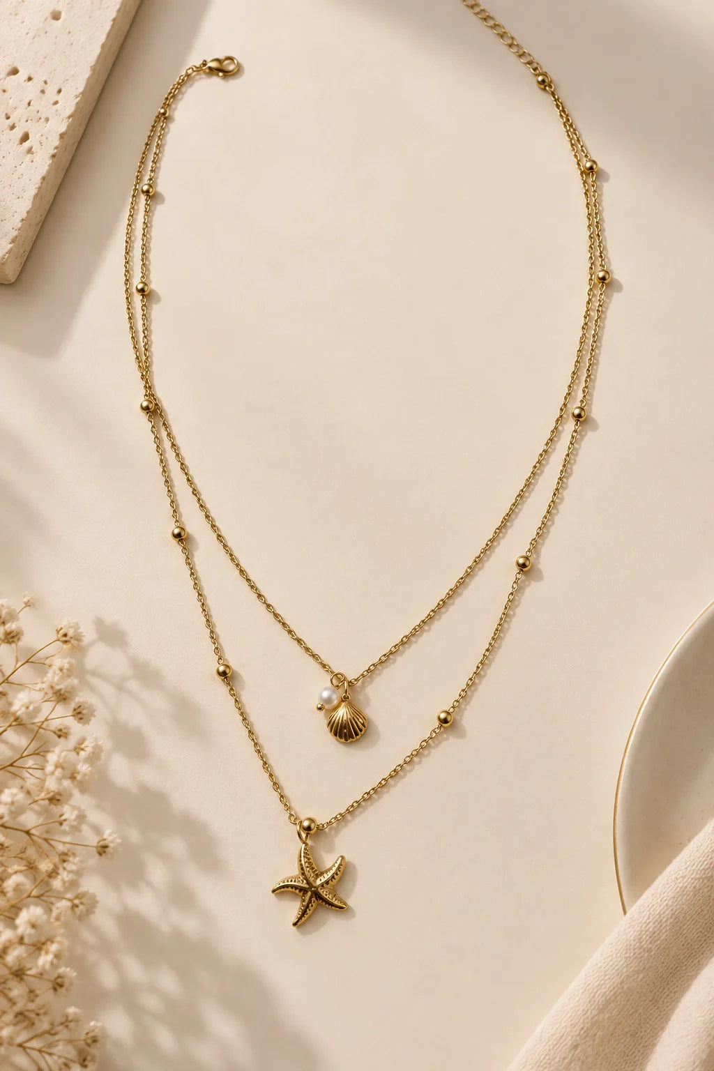 Gold-tone layered necklace with starfish and shell charms on long double chains