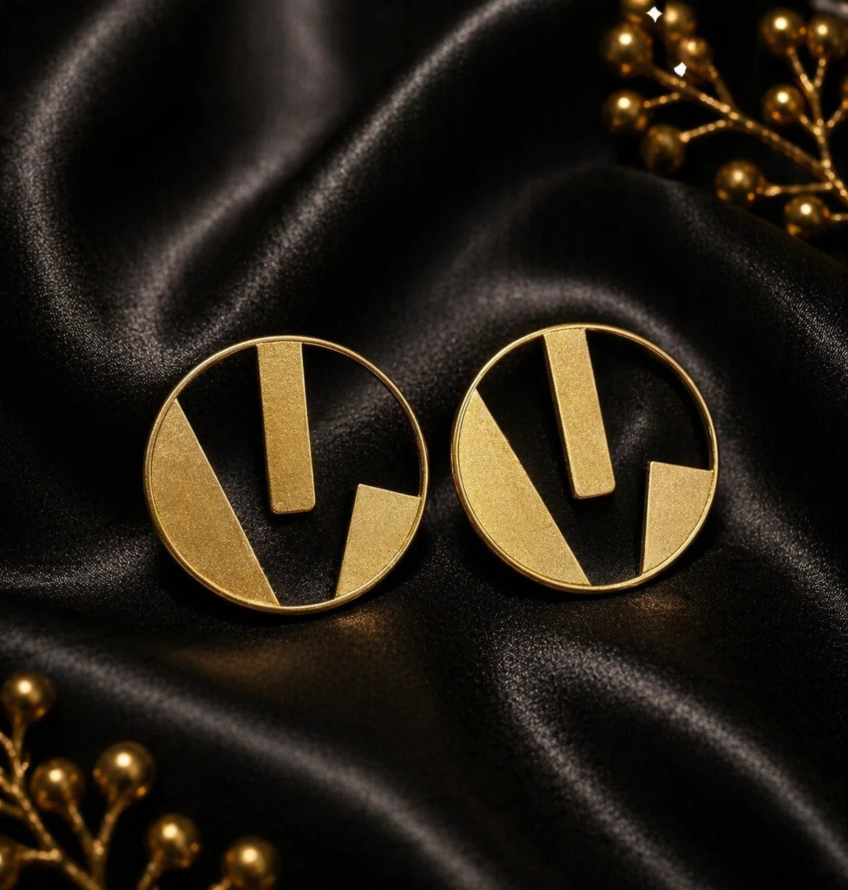 Gold circle earrings with abstract vertical bars and black inlay
