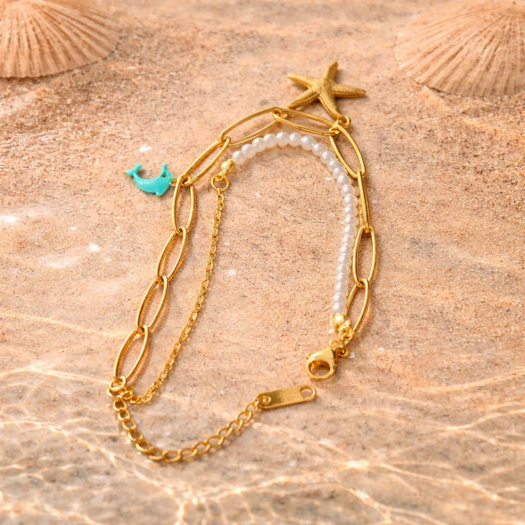 Gold charm bracelet with pearl beads, starfish and turquoise dolphin charms
