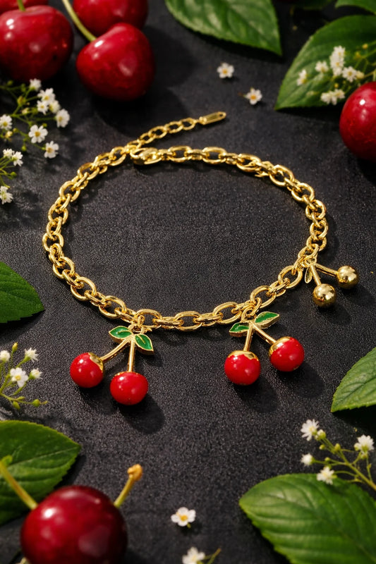 Gold link bracelet with red cherry charms and green leaf accents
