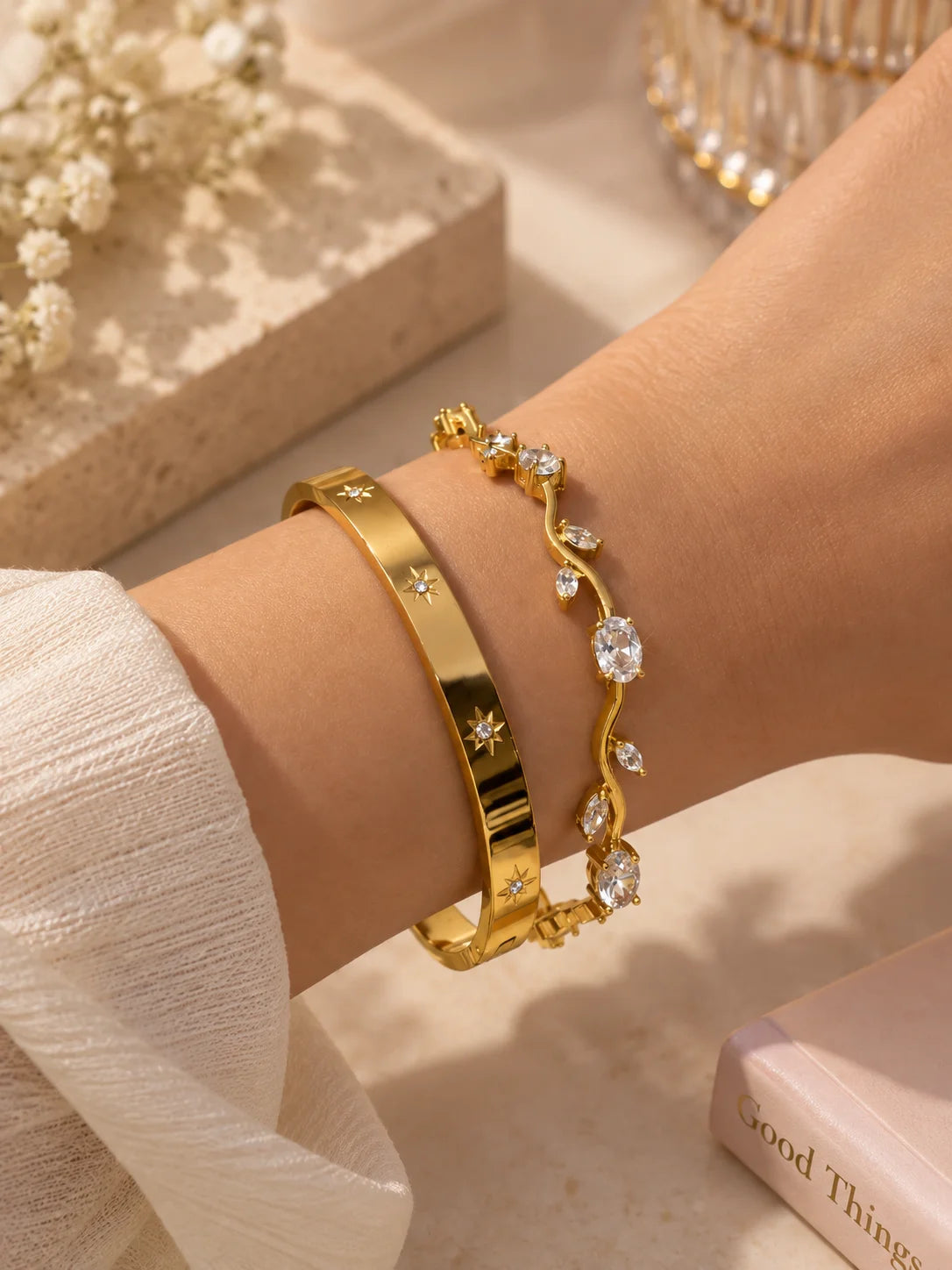 Gold kada bangle bracelet with small star-like gem stones on wrist, side view.