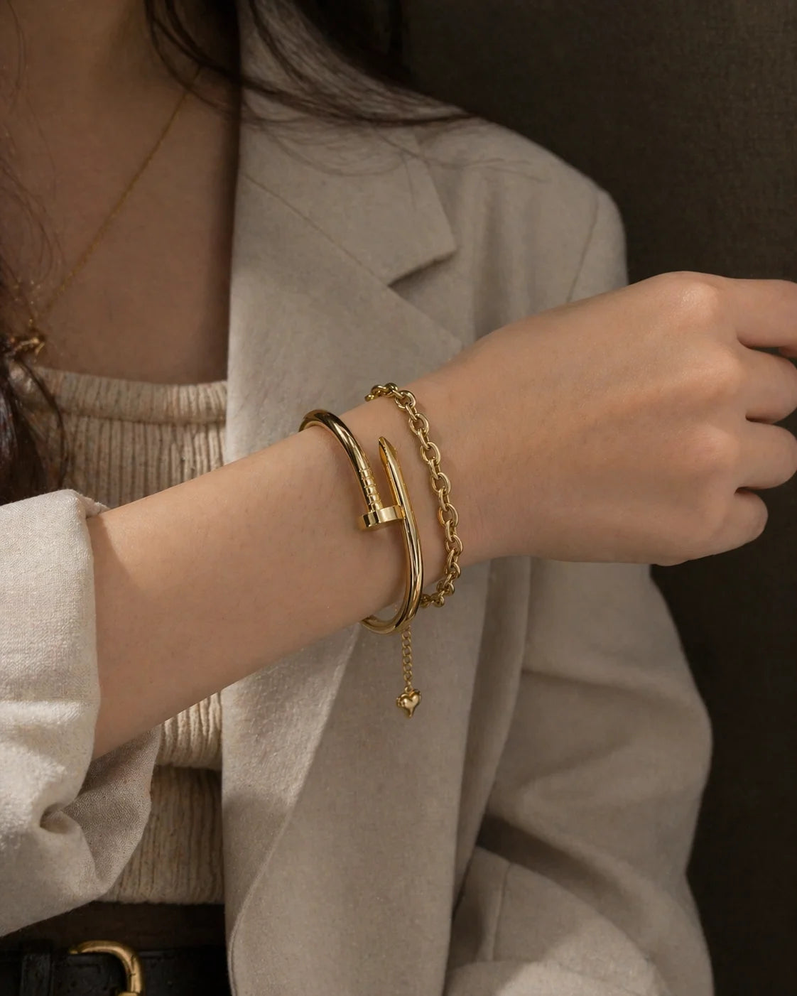 Gold link heart bracelet with small drop charm, stacked on wrist