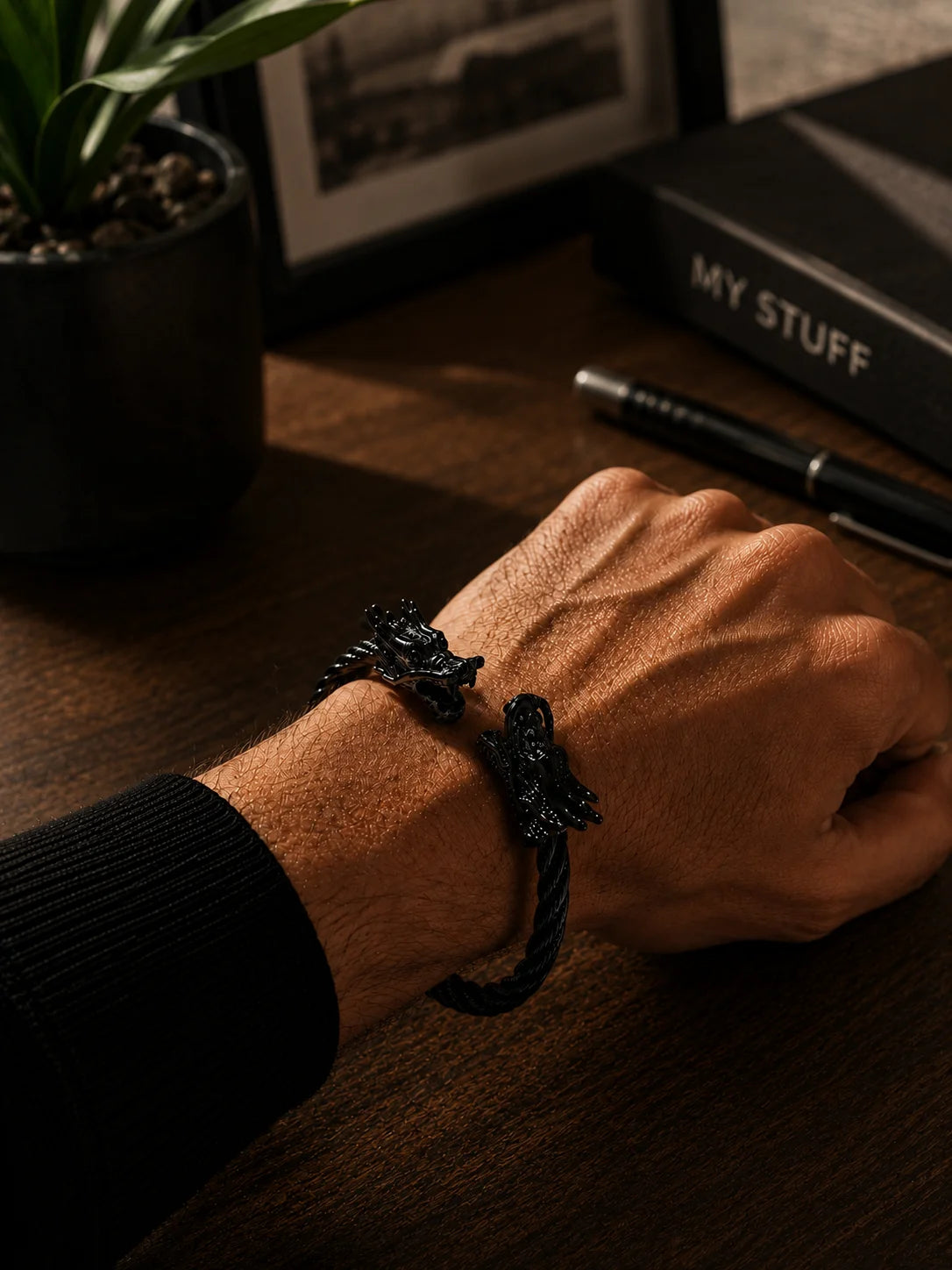 Black metal dragon kada bracelet worn on wrist with small dragon charm