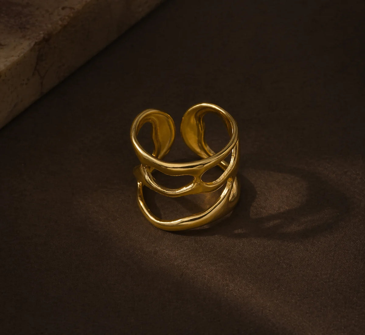 Gold statement ring with three curved open bands, close-up