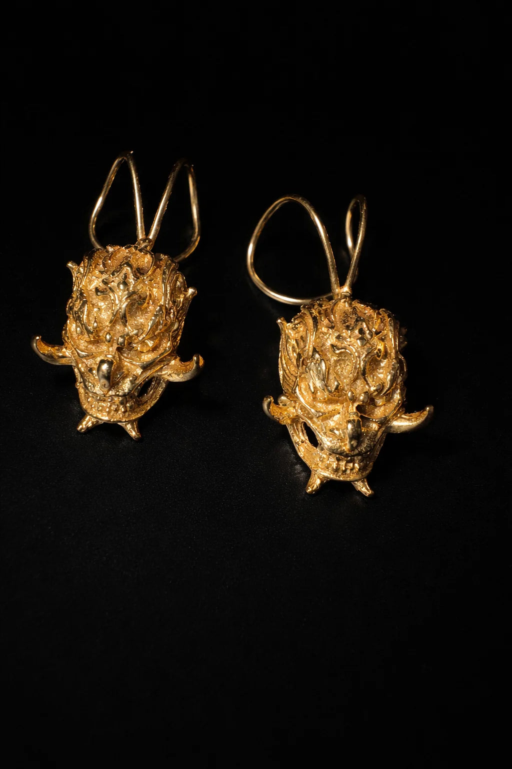Gold-tone demon face ear cuffs with curved prongs, two-piece pair