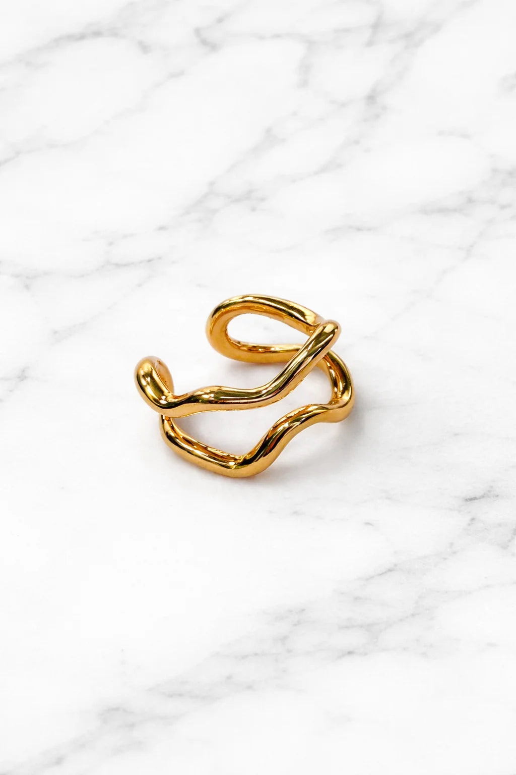 Gold-tone wavy ear cuff with open loop and curved bar for one ear