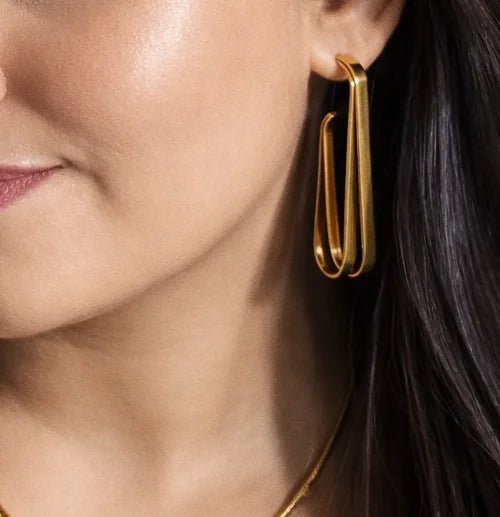 Gold-plated double U hoop earrings on model, small stud accents visible