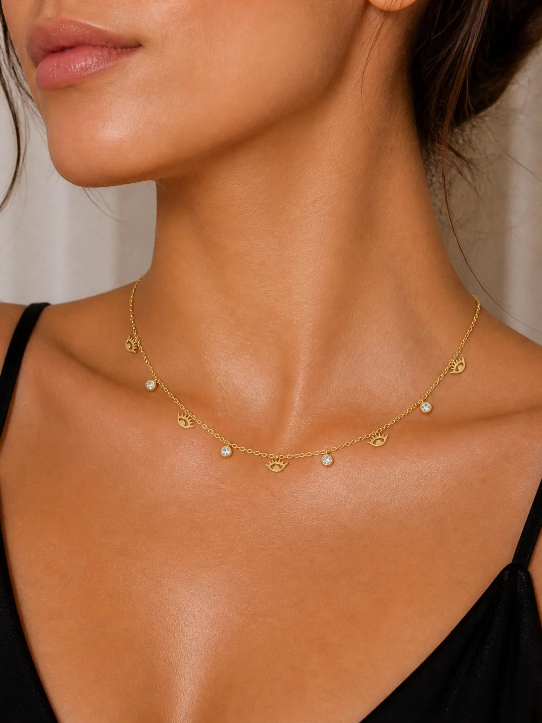 18K gold-plated charm necklace with eye and round sparkle details, gold tone