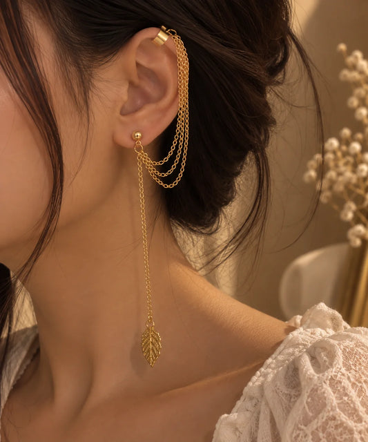 Gold ear cuff with double chain and small leaf charm dangling from hoop