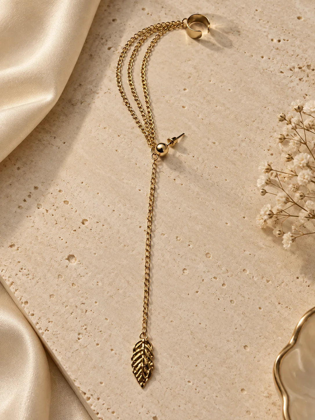 Gold one-sided ear cuff with layered chain and leaf drop charm