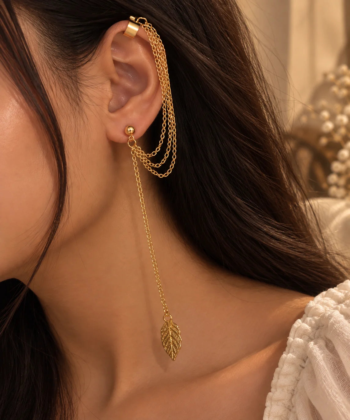Gold ear cuff with coiled chain and leaf drop charm, one-sided