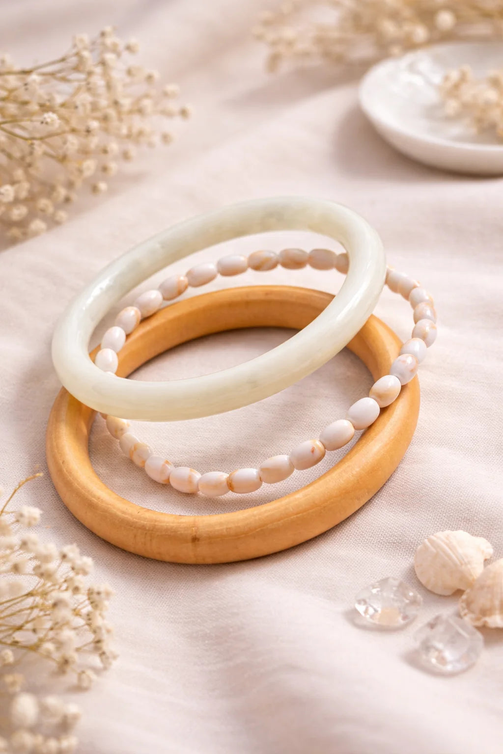 Wooden and white resin kada bangles with pearl-like beaded bracelets laid out