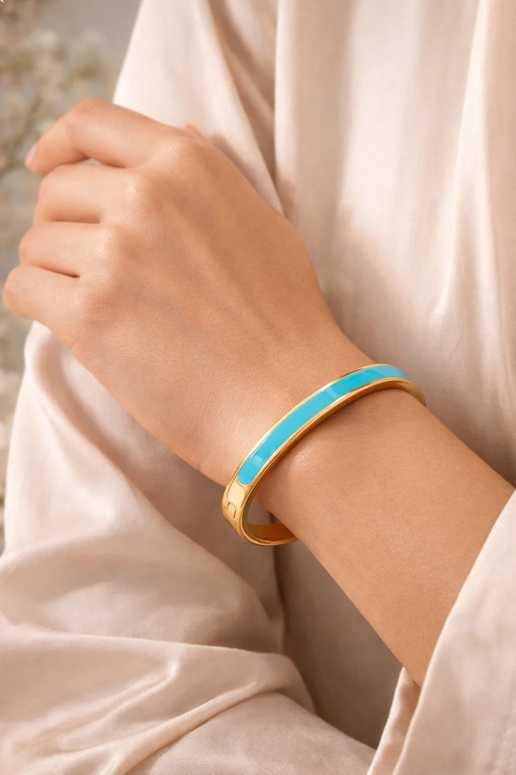 Gold-plated kada with teal enamel inlay, worn on wrist