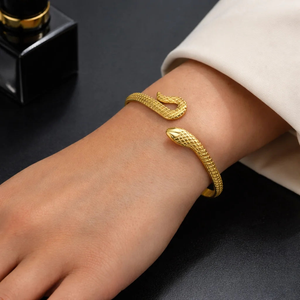 Gold snake kada bracelet with raised scale texture, worn on wrist