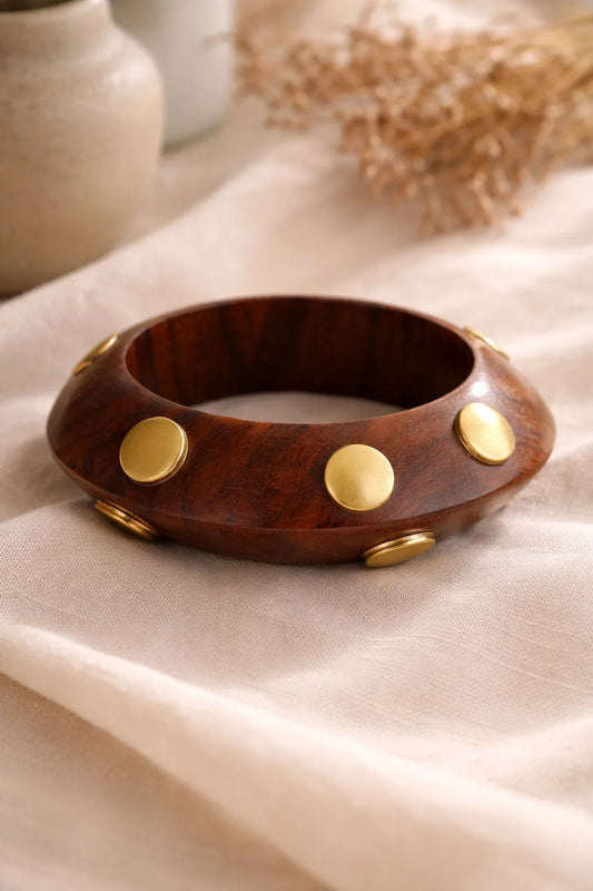Brown wooden kada-style bangle with gold disc studs along the rim