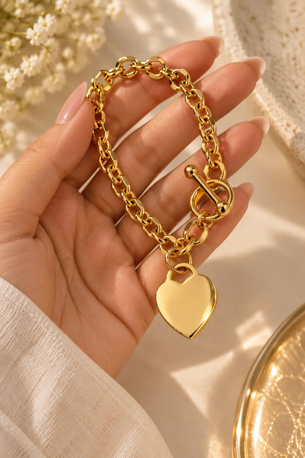 Gold tone chunky chain bracelet with heart charm and toggle clasp