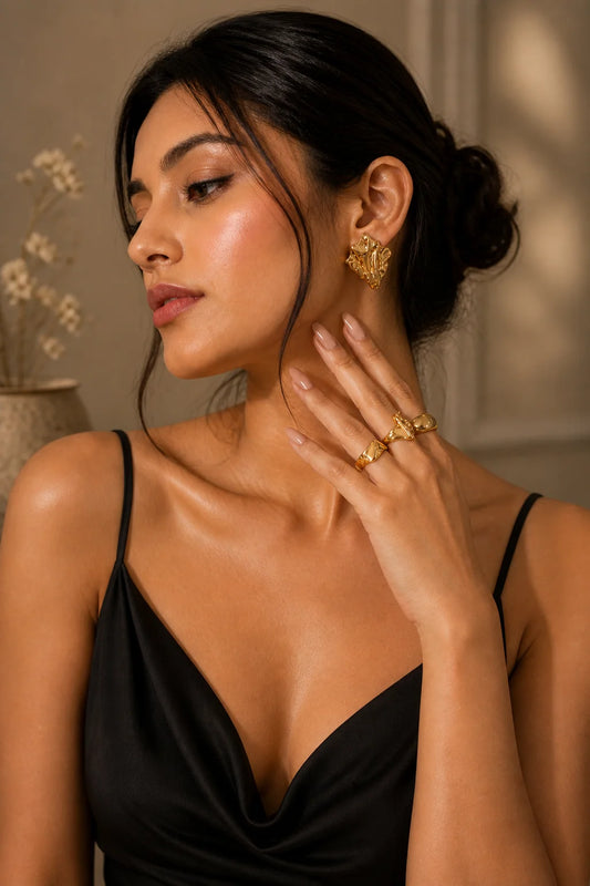 Gold-plated stud earrings with irregular melted geometric face on model