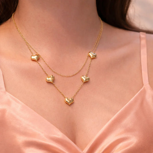 Gold-tone layered necklace with heart charms on two thin chains