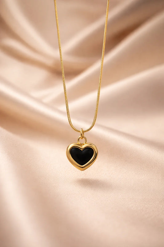 Gold heart pendant necklace with black enamel heart drop on a fine chain