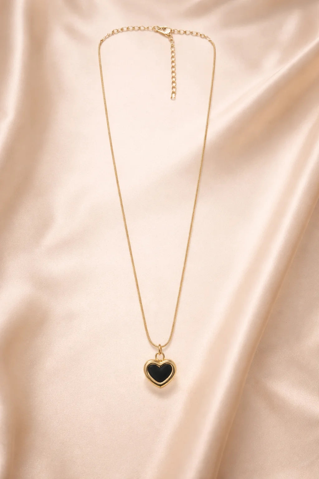 Gold chain heart pendant necklace with a black heart centerpiece