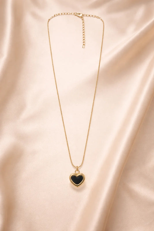 Gold heart pendant necklace with small black heart charm on a long fine chain