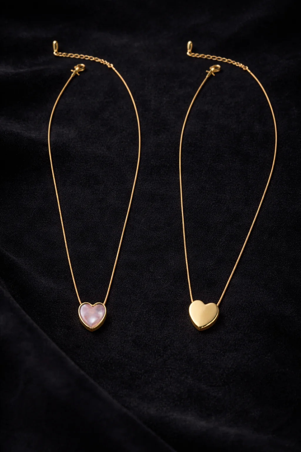 Gold heart necklace with two reversible pendants: pink and cream.