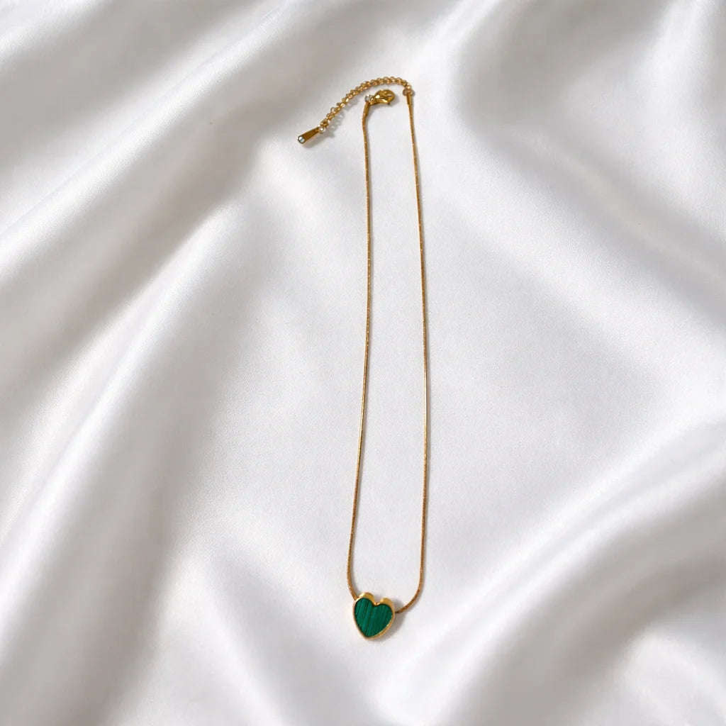 Gold necklace with small green heart pendant on long chain