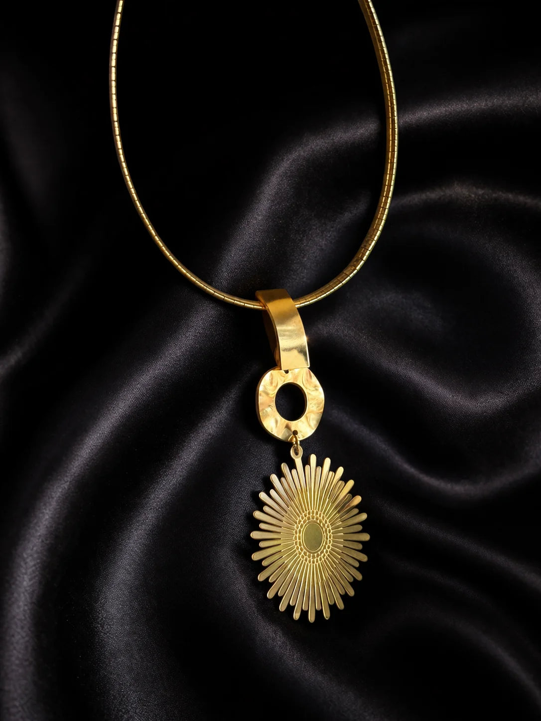 Gold statement choker with oval link and circular sunburst pendant