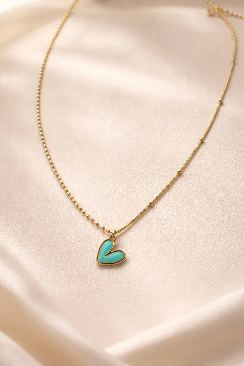 Gold necklace with turquoise heart enamel pendant on thin chain
