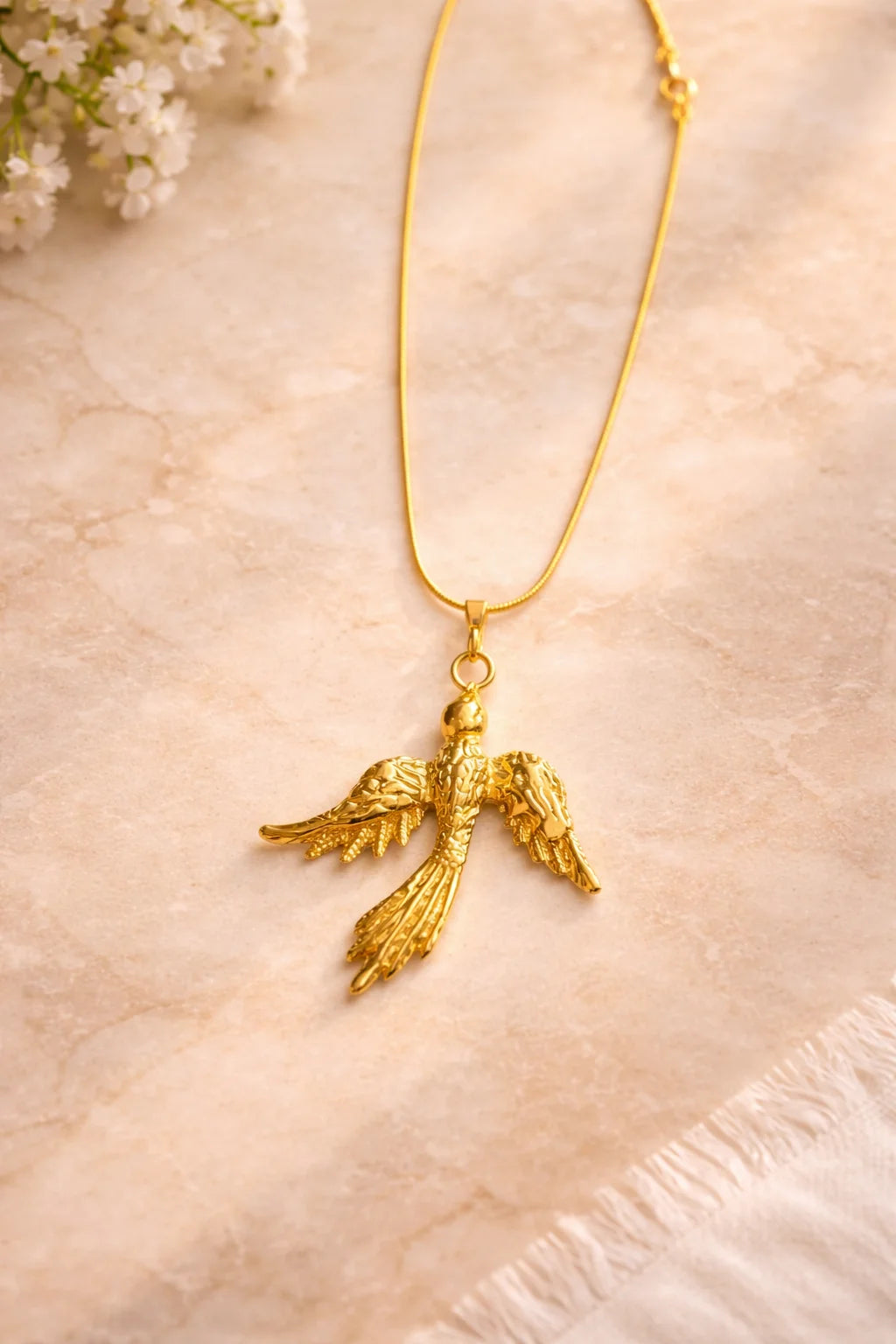 Gold phoenix pendant necklace on a short chain with small round connector links