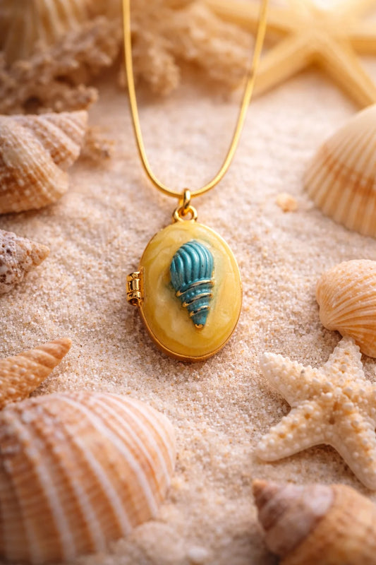 Gold-tone necklace with oval pendant and blue shell inset on amber bezel