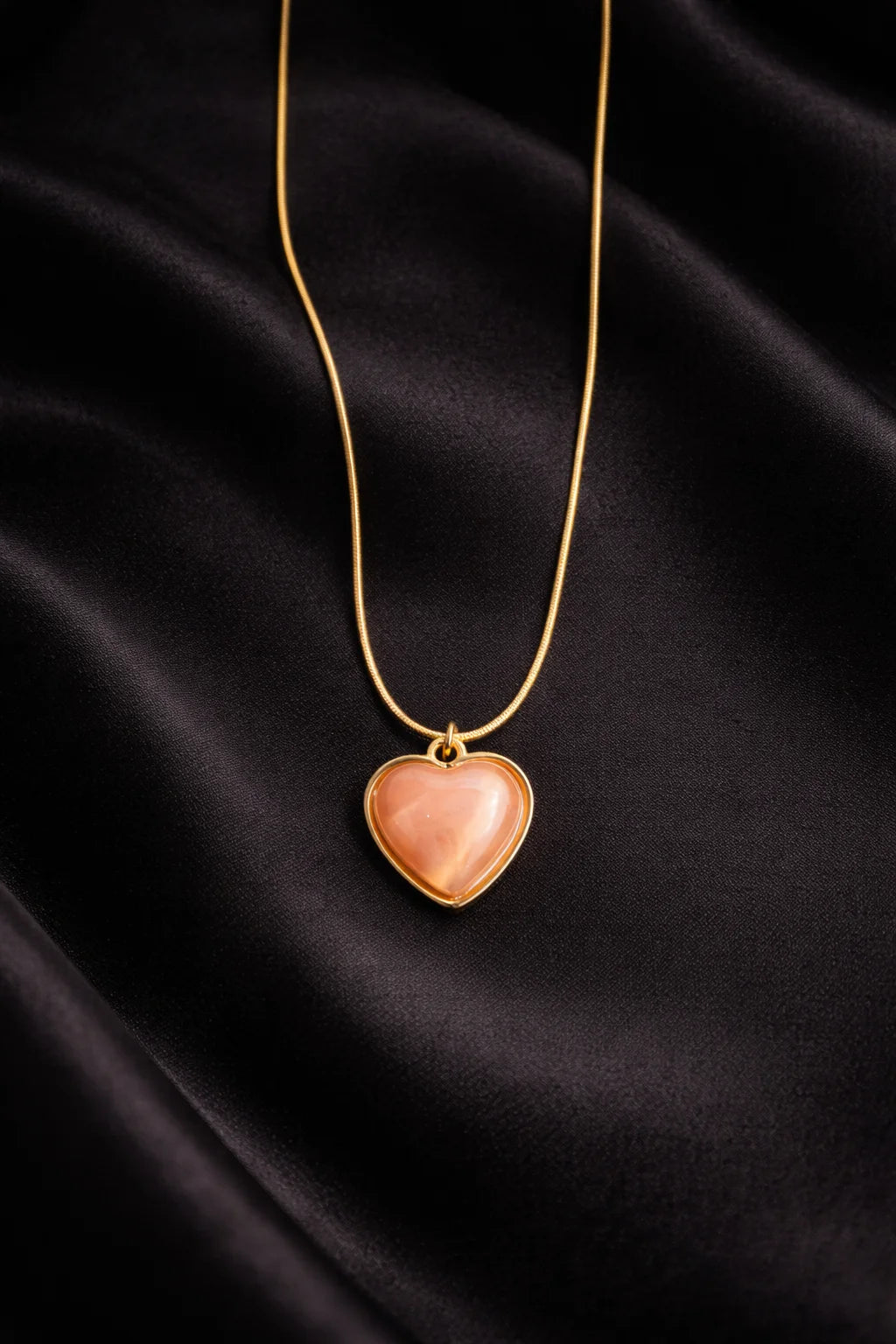 Gold-tone heart necklace with heart pendant on long chain and rose enamel center