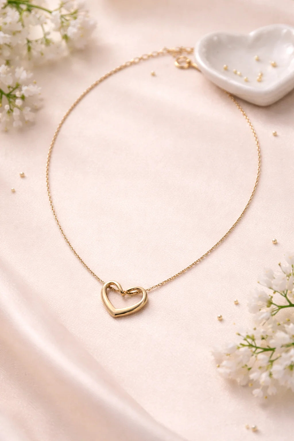 Gold heart necklace with a small outlined heart pendant on a thin chain