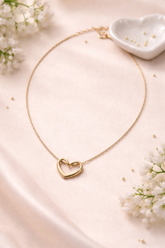 Gold heart necklace with a small outlined heart pendant on a thin chain