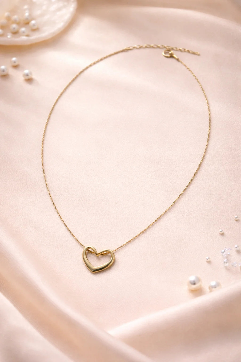 Gold heart necklace with outlined heart pendant on a delicate chain