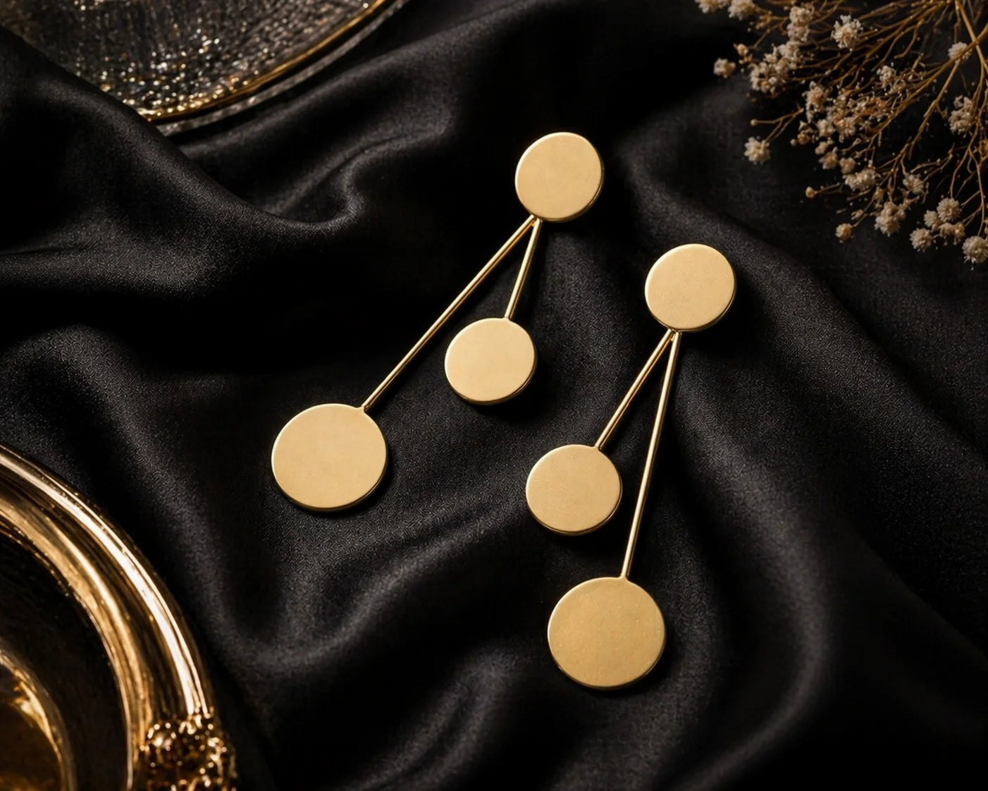Gold-tone orbit drop earrings with three round discs connected by thin bars