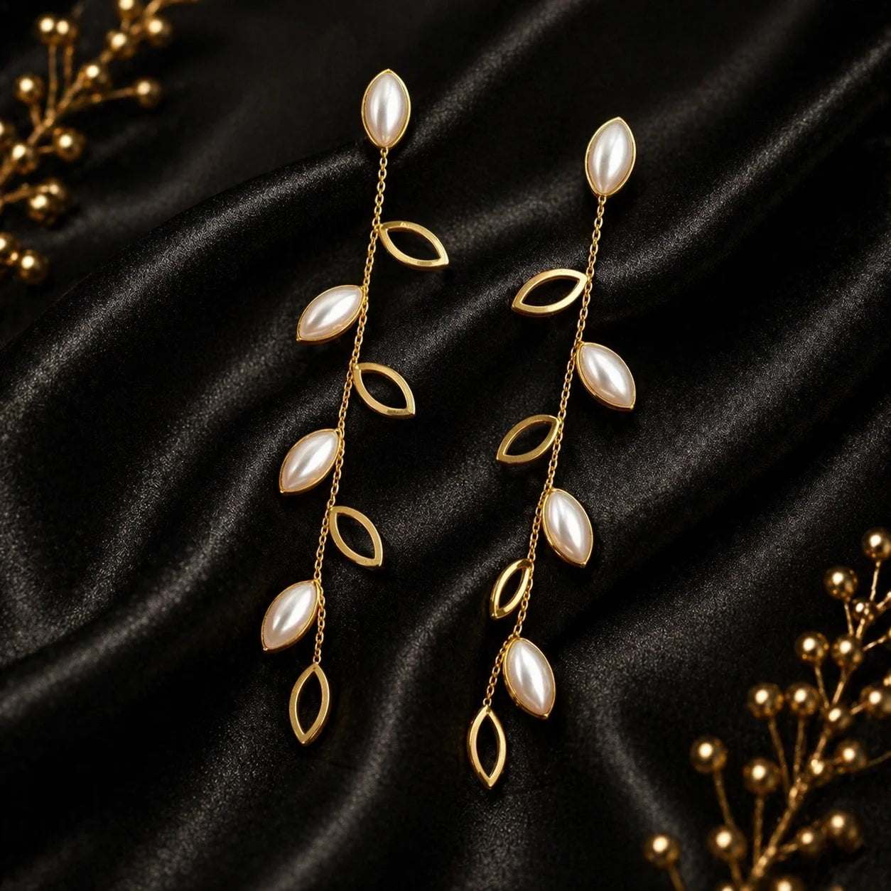 Gold-plated statement earrings with leaf drops and pearl-like teardrops