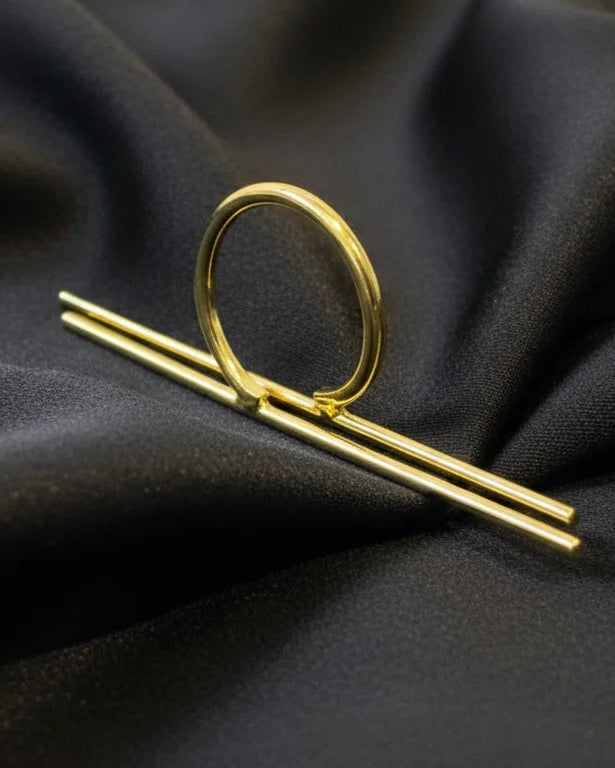 Gold-tone statement ring with oval frame and linear bar detail