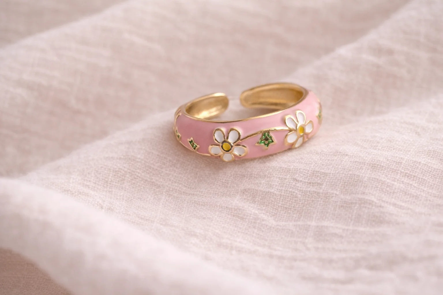 Pink enamel statement ring with gold-tone band and white flower details
