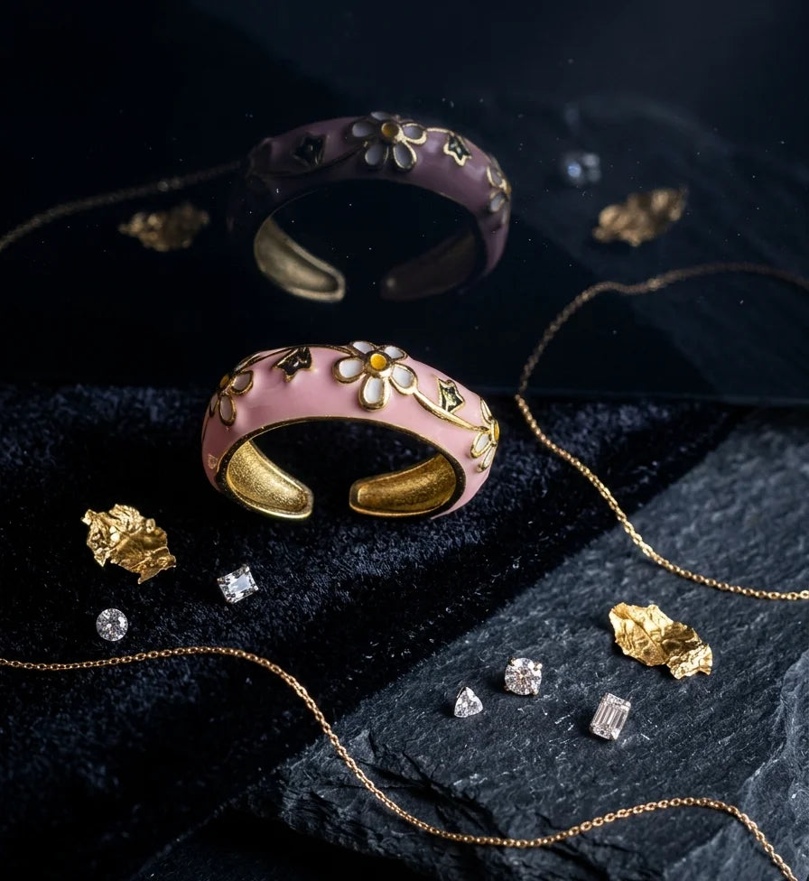 Pink enamel ring with gold-tone band and white daisy motifs with green leaves